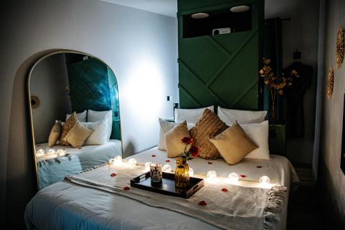 a bedroom with two beds with candles and a mirror at L'Envol - Jacuzzi, Sauna et belle vue in Cherbourg en Cotentin