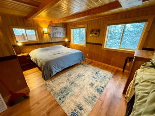 a bedroom with a bed and a rug in a room at Denali Park View Family Log Cabin in Healy