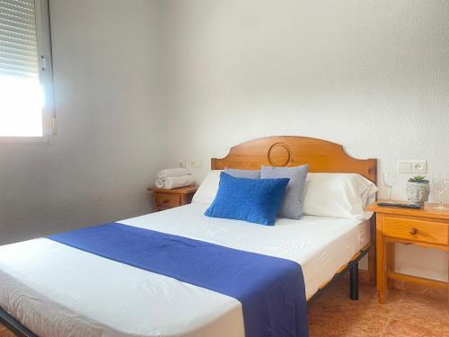 a bedroom with a large bed with blue pillows at Hotel Restaurante Costas - Fortuna in Fortuna
