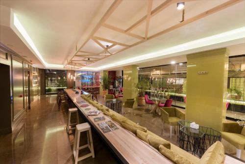 a restaurant with a long bar with chairs and tables at Nun By Laren Hotels in Antalya