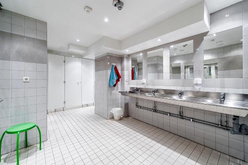 a bathroom with two sinks and a green stool at City Hostel in Stockholm