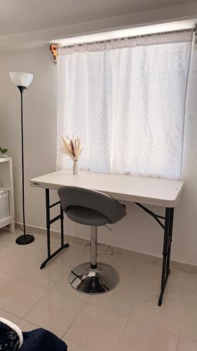 a desk with a chair in front of a window at Bed & Breakfast in El Gallinero