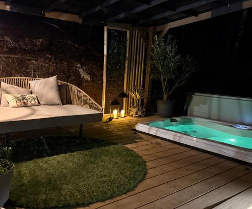 a patio with a bench and a hot tub at night at Treeangle Treehouse in Morganton