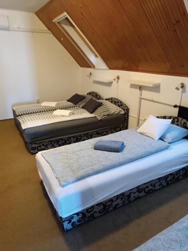 two beds sitting next to each other in a room at Pagoda Vendégház in Hajdúdorog