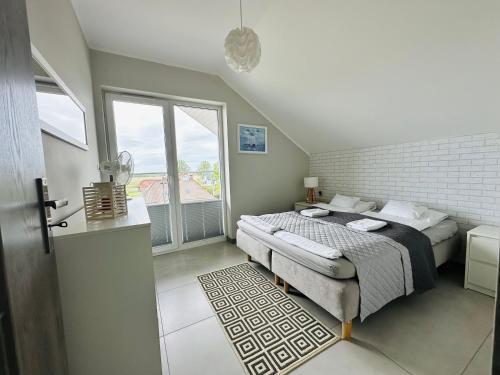 a bedroom with a bed and a large window at Willa Dobryłko II -Apartamenty in Rewa