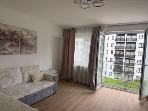 a living room with a couch and a large window at Marine Résidence in De Panne