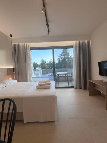 a bedroom with a bed and a view of a patio at Almondo Suites in Amigdhaleón
