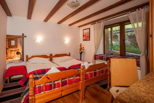 a bedroom with two beds and a window at Вила Соколето in Sokolovtsi