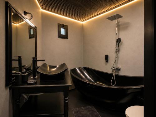 a bathroom with a black tub and a sink at Kartepe Mountain Villa in Kartepe