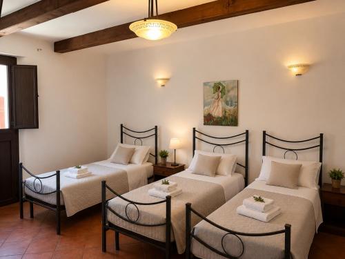 two beds in a room with two tables and chairs at Borgo Luce - Rooftop and Rooms in Francavilla Marittima