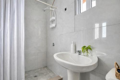 a white bathroom with a sink and a mirror at Grace Studio Roatan in Coxen Hole