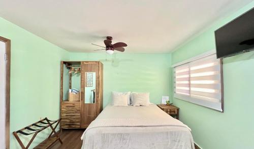 a bedroom with a bed and a ceiling fan at Grace Studio Roatan in Coxen Hole