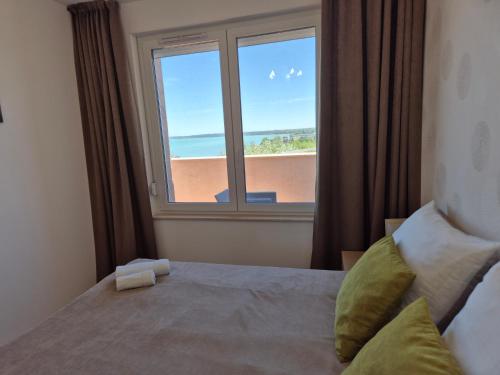 a bedroom with a window with a view of the ocean at GalériusPrémium8 in Siófok