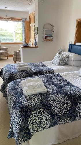 a bedroom with two beds with towels on them at 'Tanglemere' in Broadway