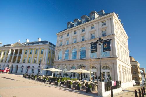 a large white building with umbrellas in front of it at The Duchess of Cornwall in Dorchester