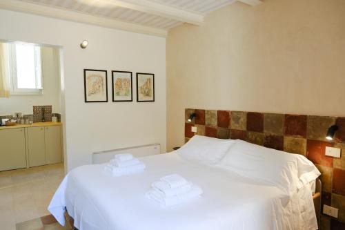 a bedroom with a white bed with towels on it at Spighe e Fenicotteri in Modica