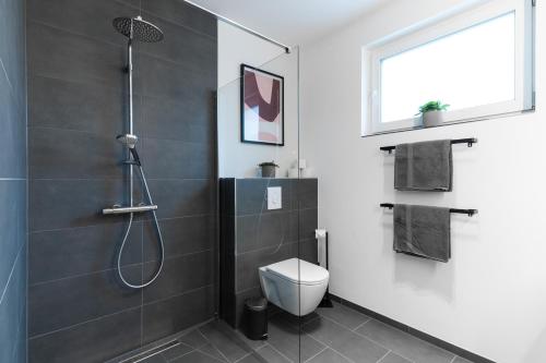 a bathroom with a shower and a toilet at Neu & modern - hej homes mit kostenfreiem Parken in Bad Kissingen