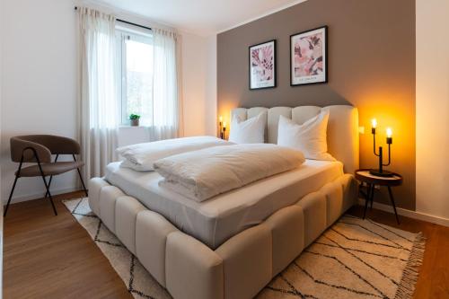 a bedroom with a large white bed with two candles at Neu & modern - hej homes mit kostenfreiem Parken in Bad Kissingen