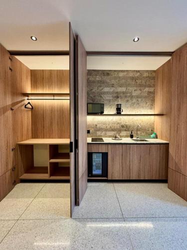 an open door to a kitchen with wooden cabinets at Iconik Hotel in Medellín