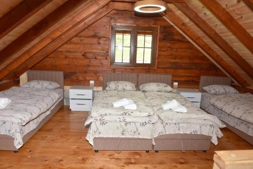 a bedroom with two beds in a log cabin at Vila Teodora in Mojkovac