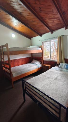 a bedroom with two bunk beds and a window at Cabañas Ohiggins in Dalcahue