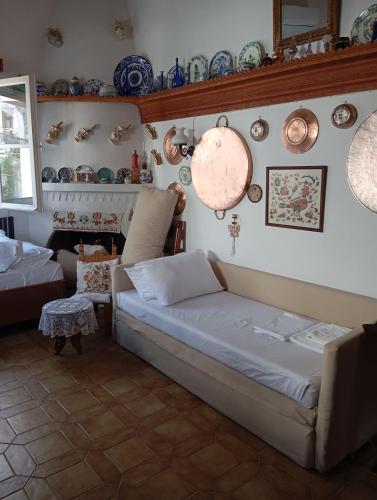 a living room with a couch and plates on the wall at Myrto's traditional house in Skiros