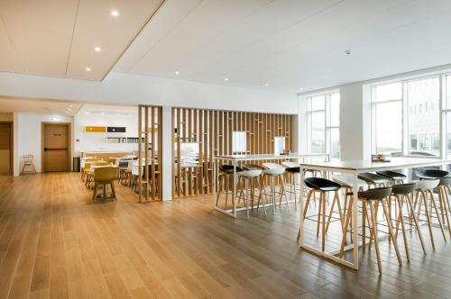 a large room with wooden floors and bar stools at Storm Hotel by Keahotels in Reykjavík