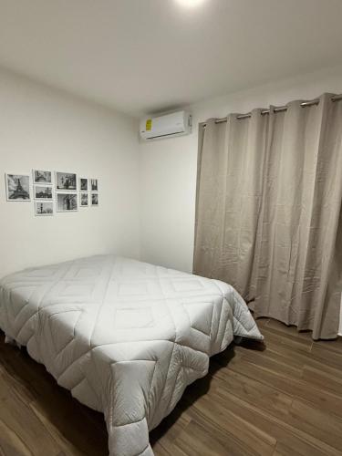 a white bedroom with a bed and a window at Nice downtown apartment Veracruz in Veracruz