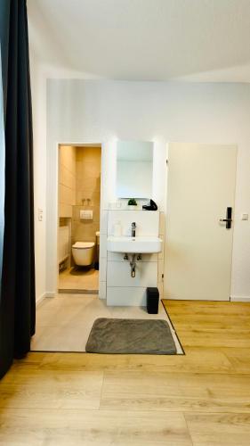 a bathroom with a sink and a toilet at Aparthotel Grünewald in Hannover