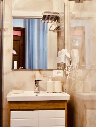 a bathroom with a sink and a mirror at Demaj House in Grilë