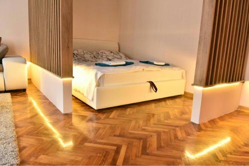 um quarto com uma cama e piso em madeira em Bojan Central Apartment em Novi Sad