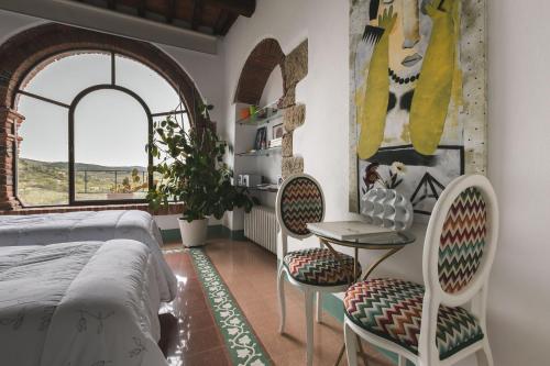 a bedroom with a bed and two chairs and a table at Casa Marelli in Castelmuzio