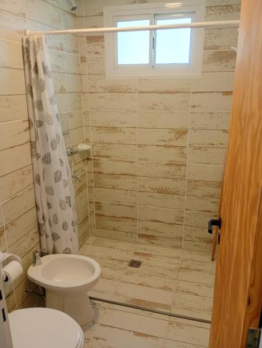 a bathroom with a toilet and a shower at Complejo ruka del pinar in San Ignacio