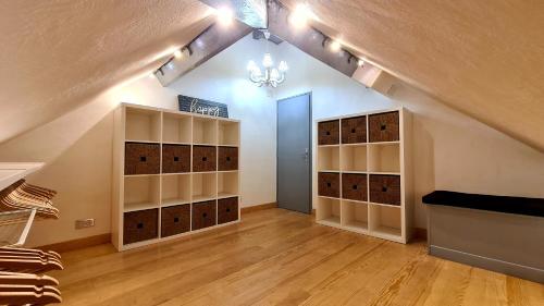 an attic room with shelves and a room with a staircase at Ma chaumiere in Les Cammazes