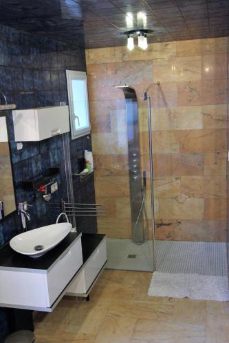 a bathroom with a glass shower and a sink at Ma chaumiere in Les Cammazes