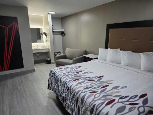 a hotel room with a bed and a chair at Red Roof Inn Green Brook - Somerset in Green Brook