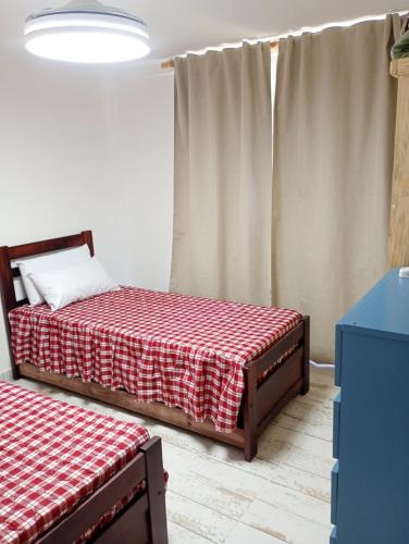 a bedroom with two beds with a red and white blanket at Complejo ruka del pinar in San Ignacio