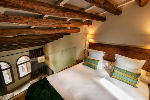 a bedroom with a white bed with two pillows at Cal Compte in Torroja