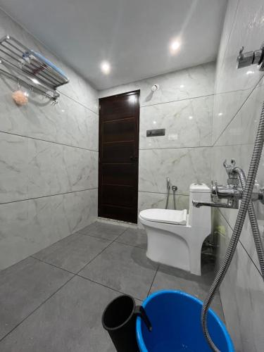 a bathroom with a toilet and a sink and a shower at Writer's Inn in Vaikom