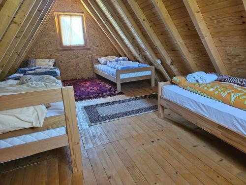 a room with three beds in a log cabin at Camp Volujak in Gacko