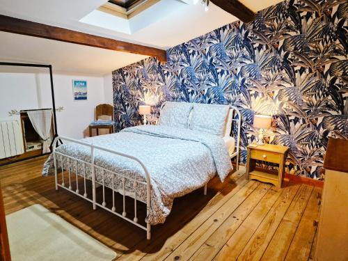 a bedroom with a bed and a blue and white wallpaper at La Grue Gites in Mons