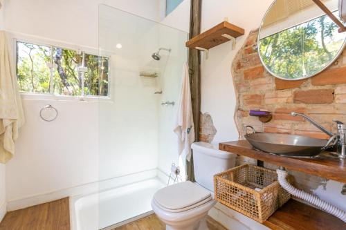 a bathroom with a sink and a toilet and a tub at Cabana Paiol de Baixo in Curitiba