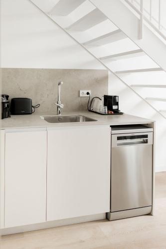 a kitchen with white cabinets and a stainless steel dishwasher at SuiteStays Marino Albesa - Ayora, Valencia in Valencia