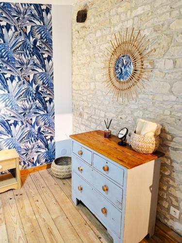 a blue dresser with a mirror on a wall at La Grue Gites in Mons