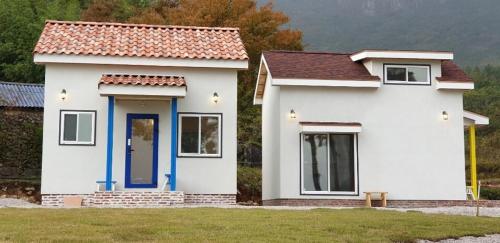a small white house with a red roof at Full Moon Dalbawi Pension in Jangheung
