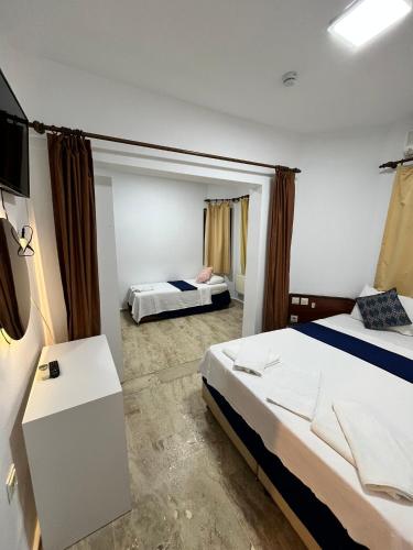 a hotel room with two beds and a television at Han Dalyan Hotel in Dalyan