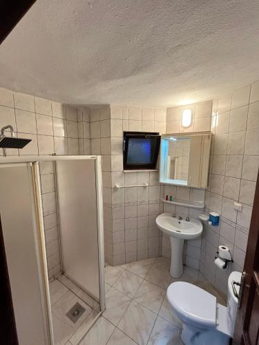 a bathroom with a shower and a toilet and a sink at Han Dalyan Hotel in Dalyan