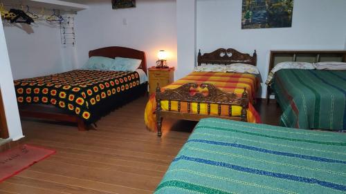 a room with two beds and a table with a lamp at Casa Mirita in Cajamarca