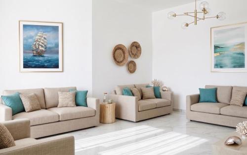 a living room with two couches and a chandelier at Amare boutique Hotel in Salerno Airport - Aeroporto di Salerno