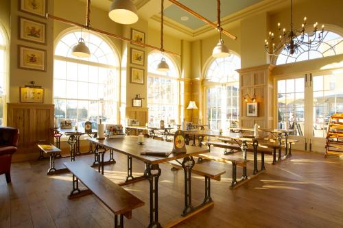a large room with tables and chairs and windows at The Duchess of Cornwall in Dorchester